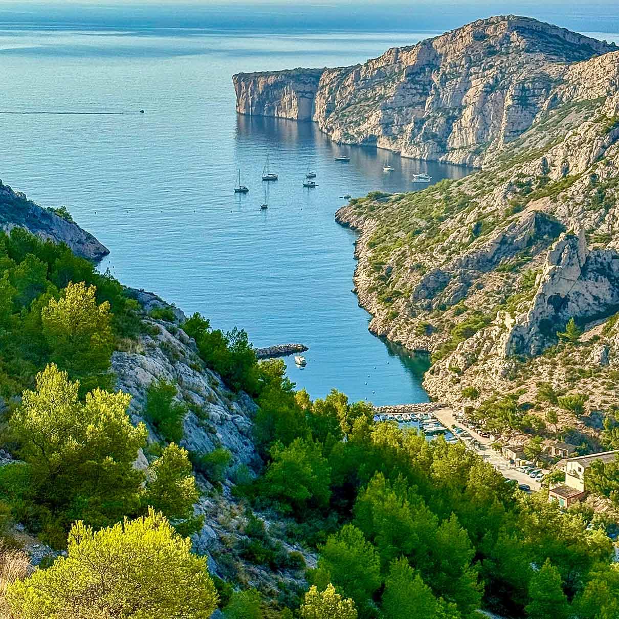 Vue plongeante sur le port de Morgiou et ses voiliers protégés par de hautes falaises.