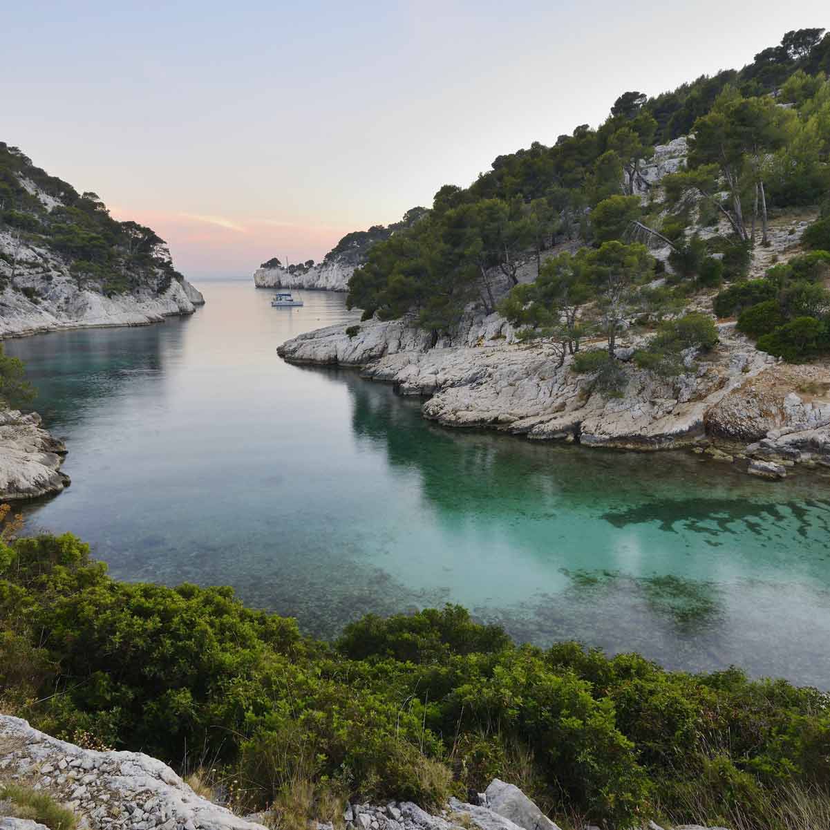 Vue paisible au crépuscule sur les eaux calmes et les falaises boisées de Port-Pin.