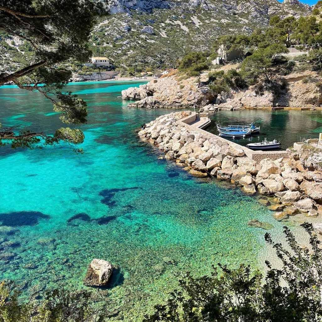 Petit port de pêche aux eaux turquoise avec jetée en pierre à Sormiou.