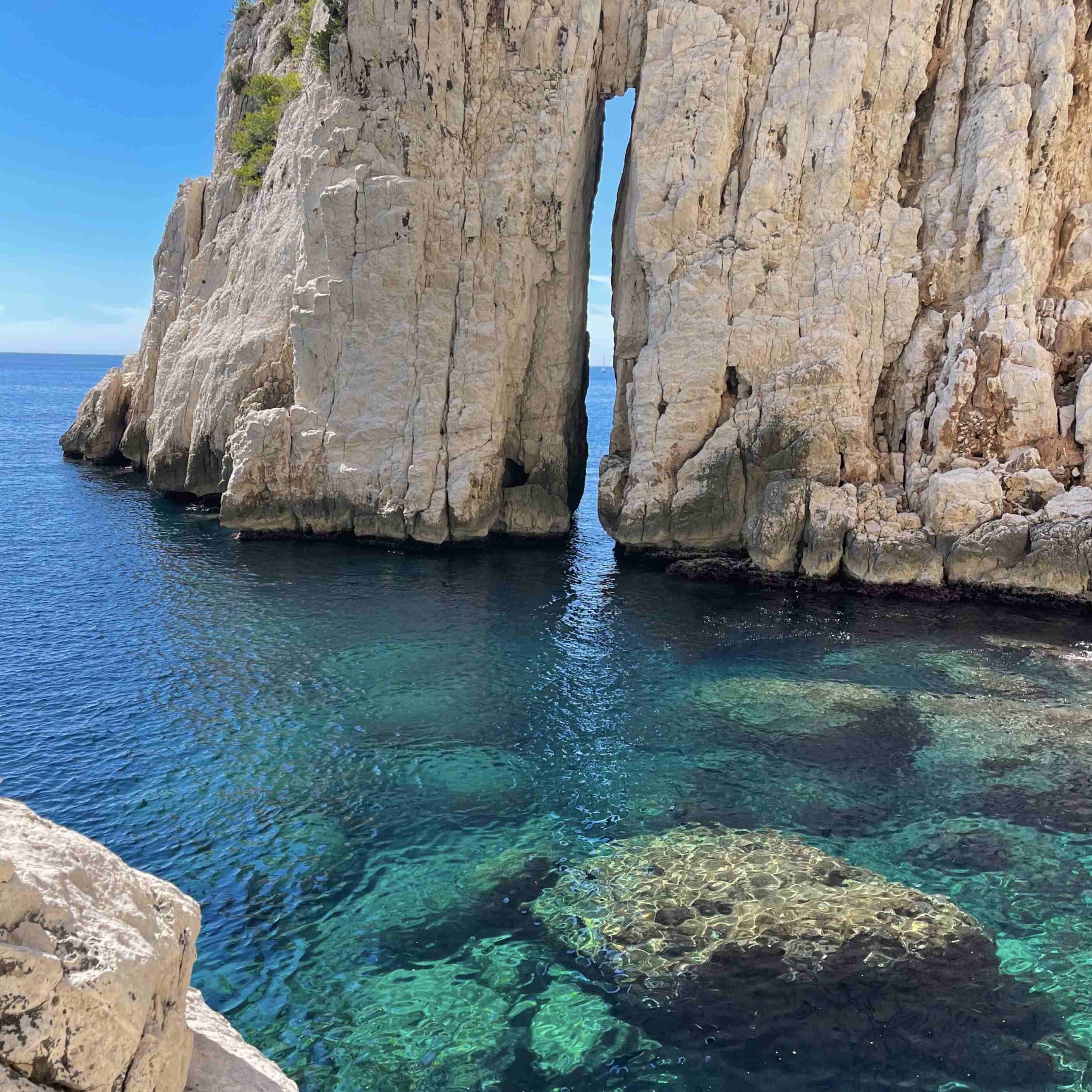 Deux paddles naviguant sur l'eau transparente de la calanque de Sugiton.
